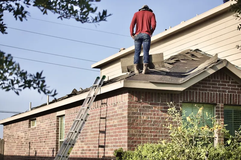 Professional roofer working on a residential roof in Sagefield